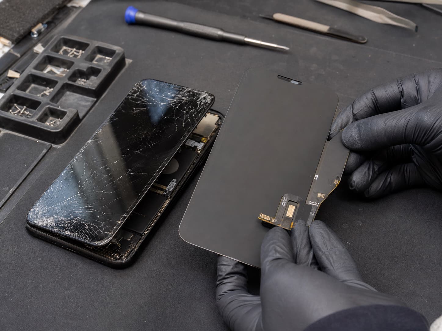 Gebarsten telefoonscherm naast een vervangend display